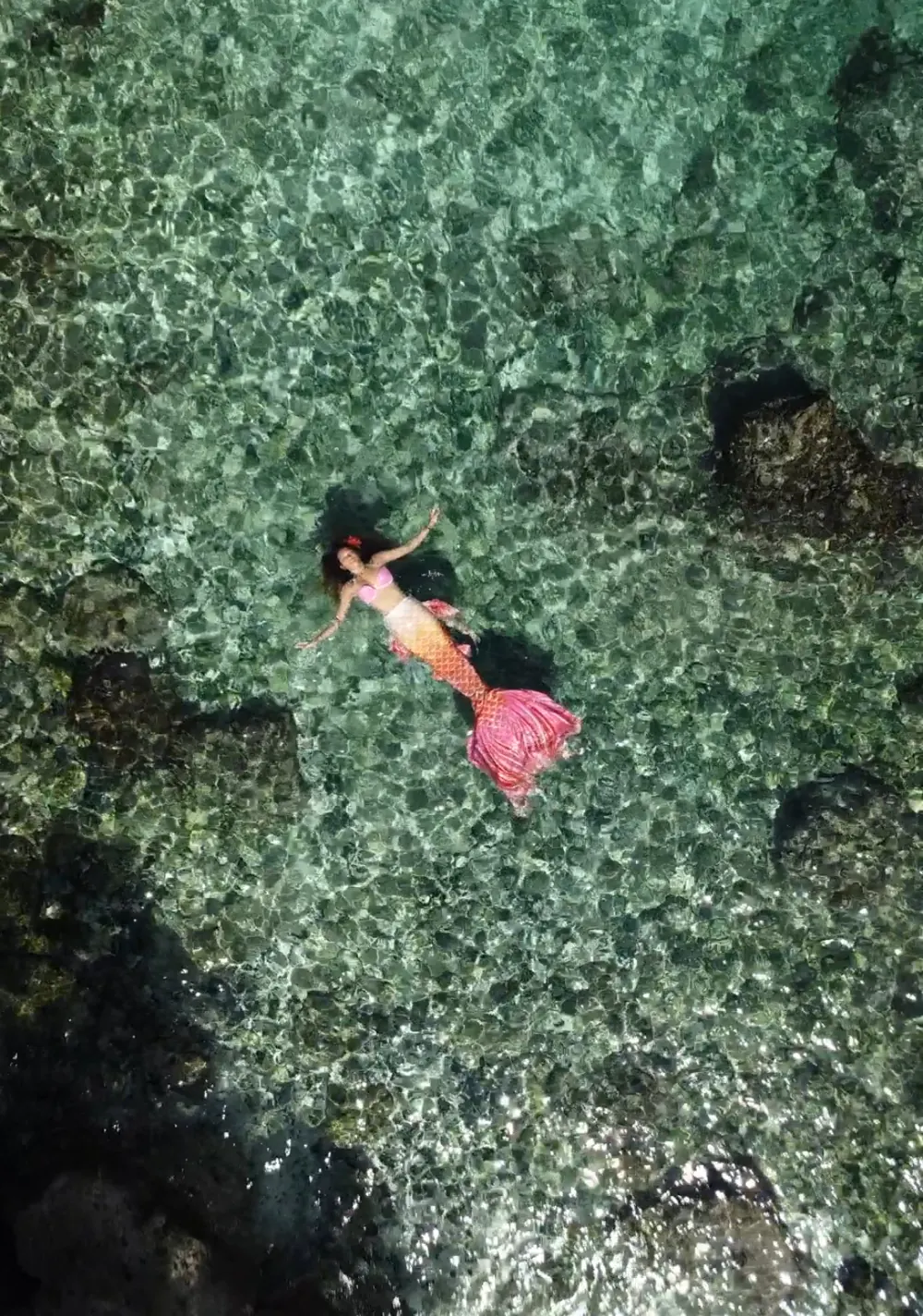 A mermaid floating over the reef, seen from above